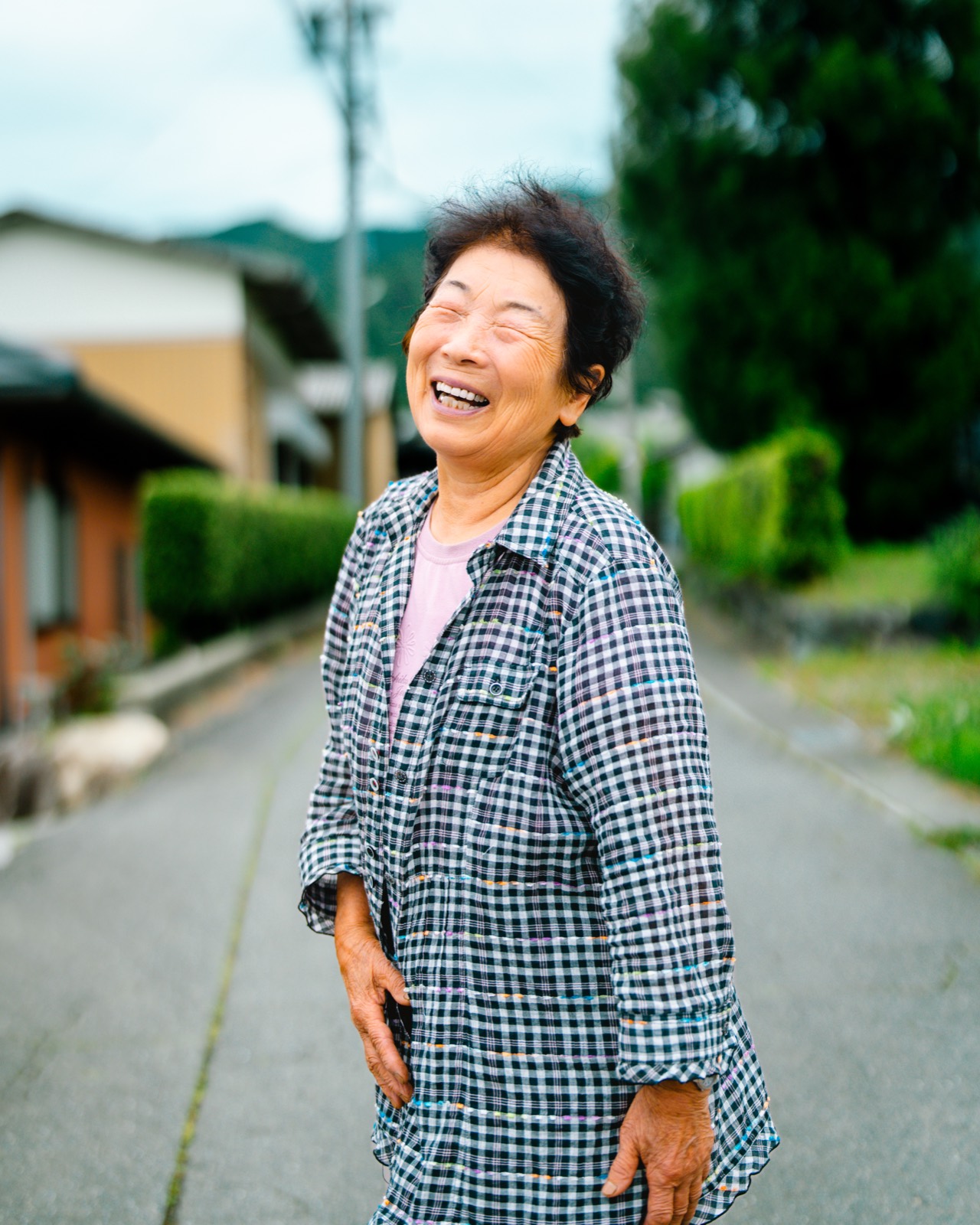 集落の道で笑うおばあちゃん