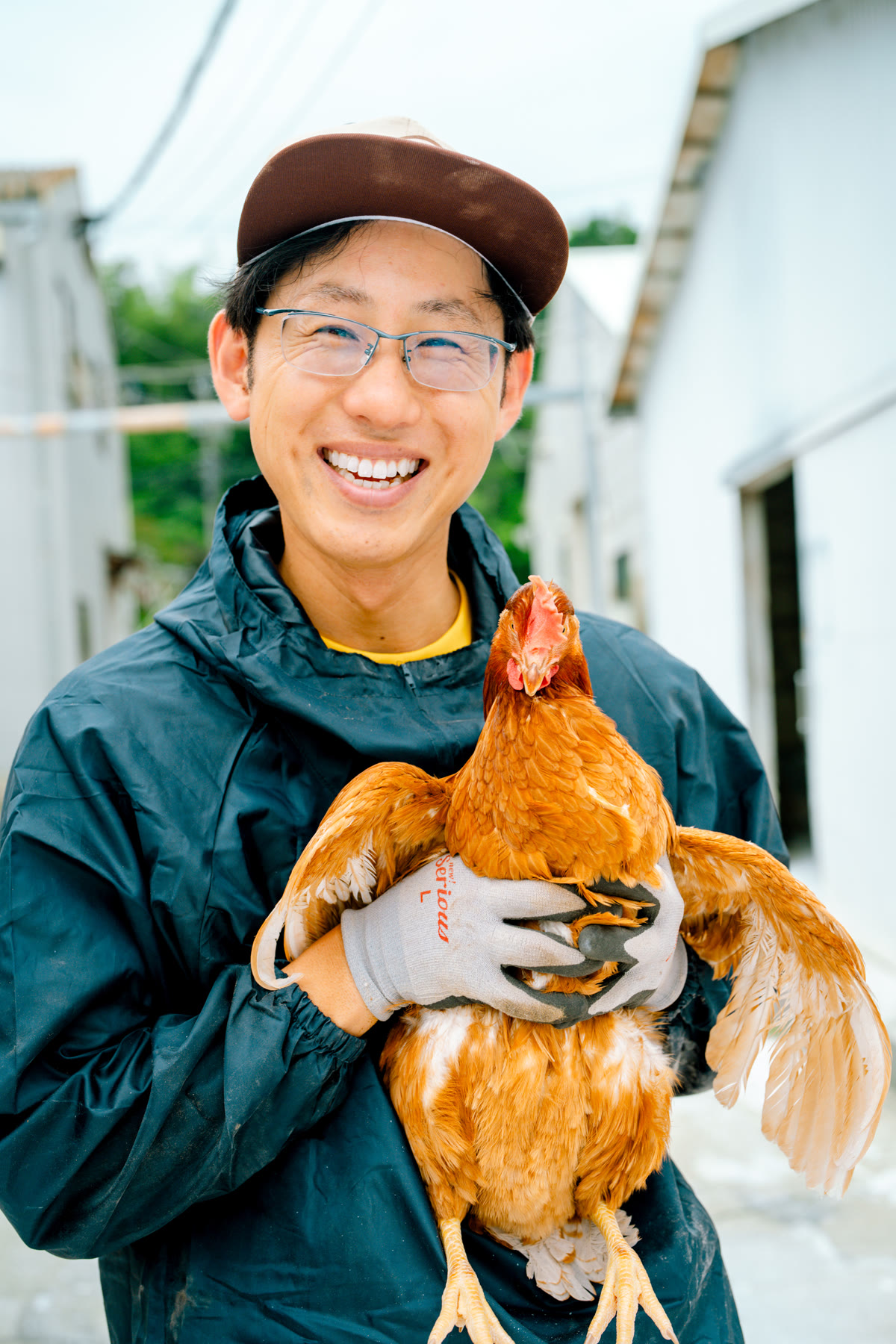 鶏を抱く鳥鹿養鶏園の生産者